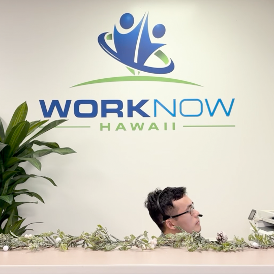 A person sitting at the reception desk for Work Now Hawaii